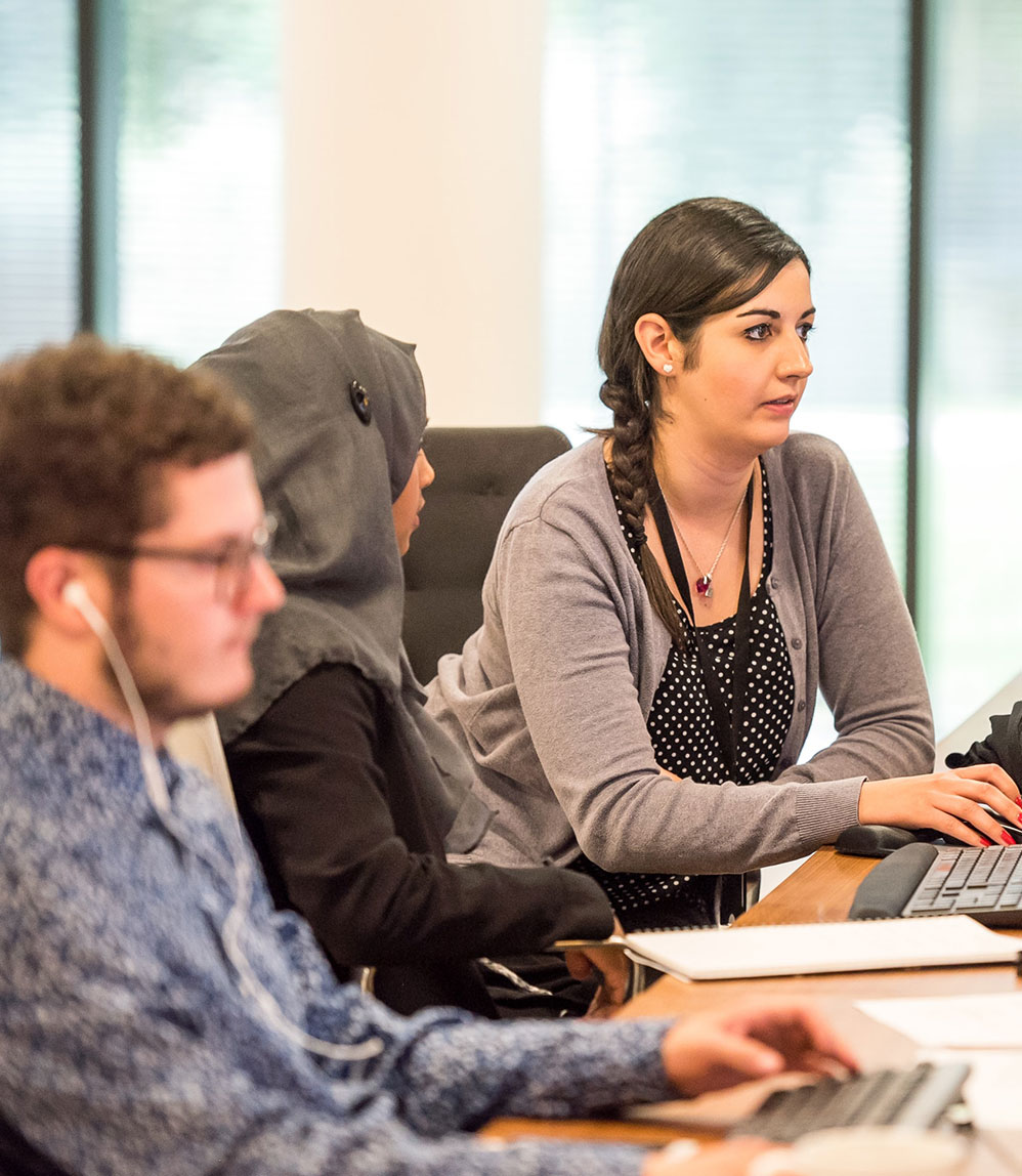 Three workers on computers in an office